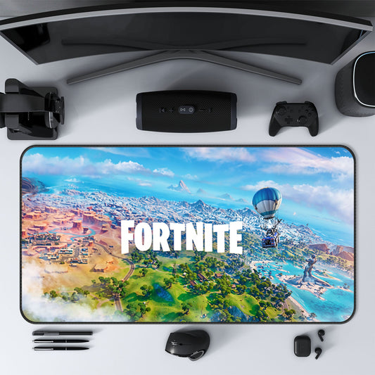Un bureau de jeu avec un tapis de souris de jeu XXL représentant l'île Fortnite, entouré d'un moniteur, d'un contrôleur, d'un haut-parleur, d'un casque et d'accessoires.